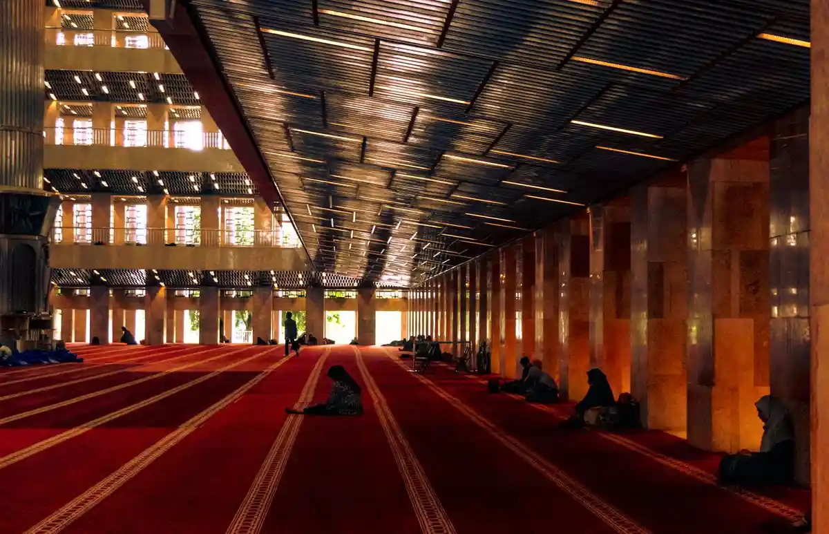 A grand mosque interior with a congregation in prayer